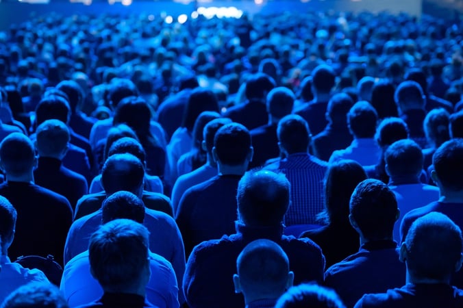 A crowd of people facing a stage