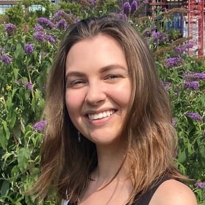 Alicia Moeller standing in front of a flower garden, smiling at the camera