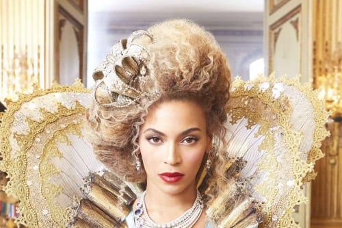 Beyonce dressed in a golden Elizabethan style gown and hair