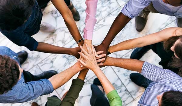 Team Of Diverse Workers Put Hands Together