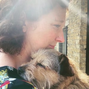 Bryony is a white woman with curly hair, pictured with her dog Rita