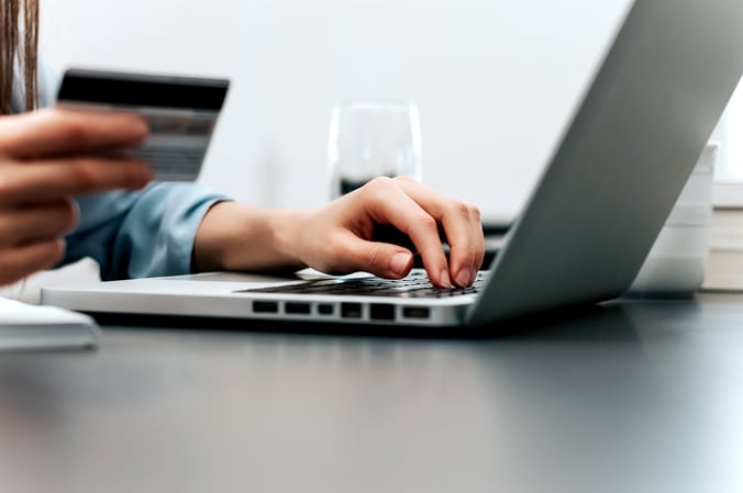 A hand typing on a laptop