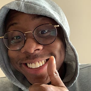 A head shot of Hakeem Buge smiling and giving a thumbs up in a selfie.