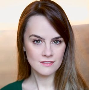 A headshot of Rachel Thomas, who is wearing a dark green top and looking into the camera.