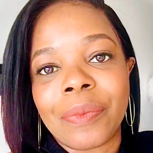 A headshot of Thembi wearing a pair of earrings she designed and made herself