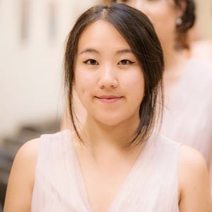 Laishan Chu wearing a white dress, looking directly into the camera