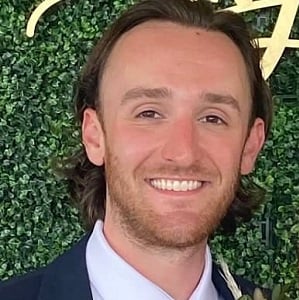 Sean OConnor, a young man in a tux, standing for a photo at his friends wedding