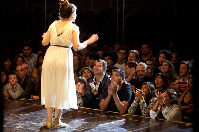 A performer onstage addresses a rapt audience